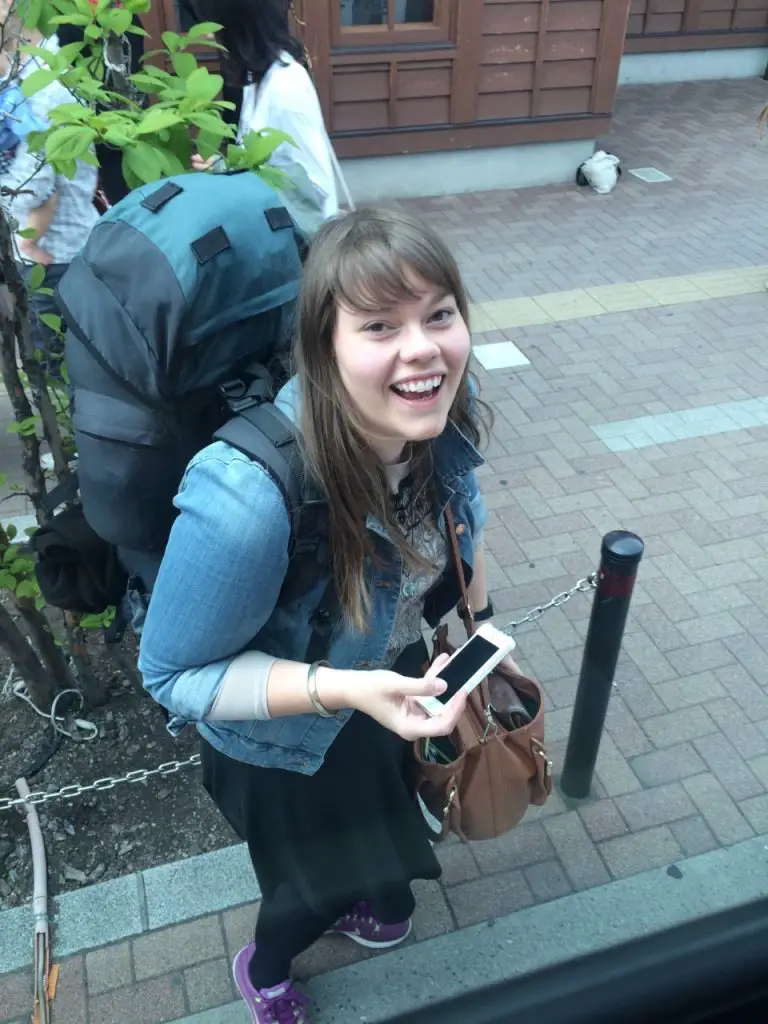lauren wild lovely world smiling with backpack
