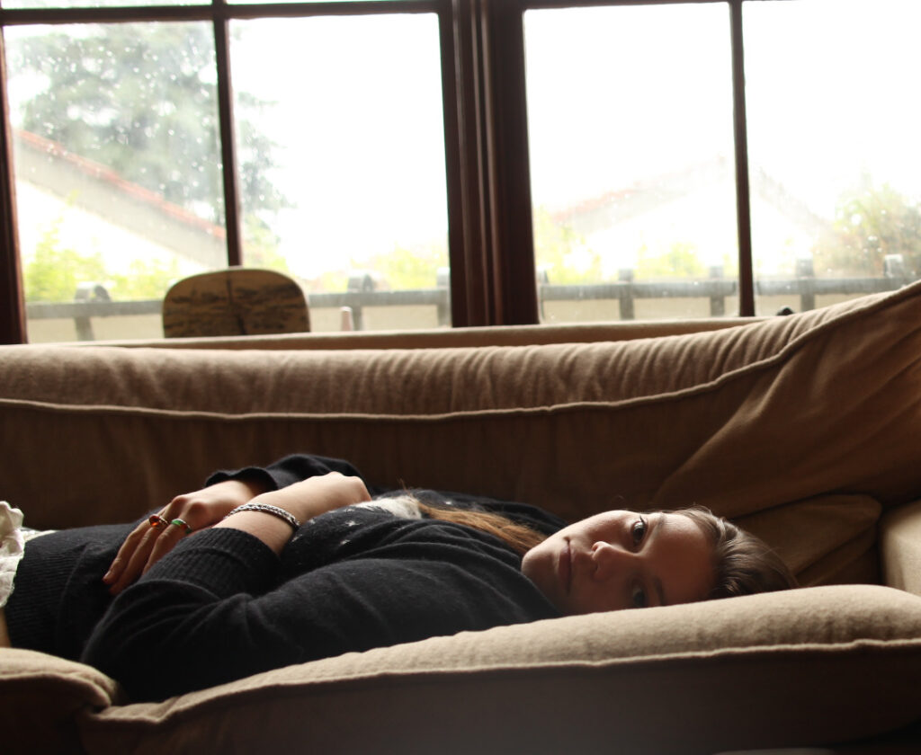 lauren lying on a couch looking into the camera