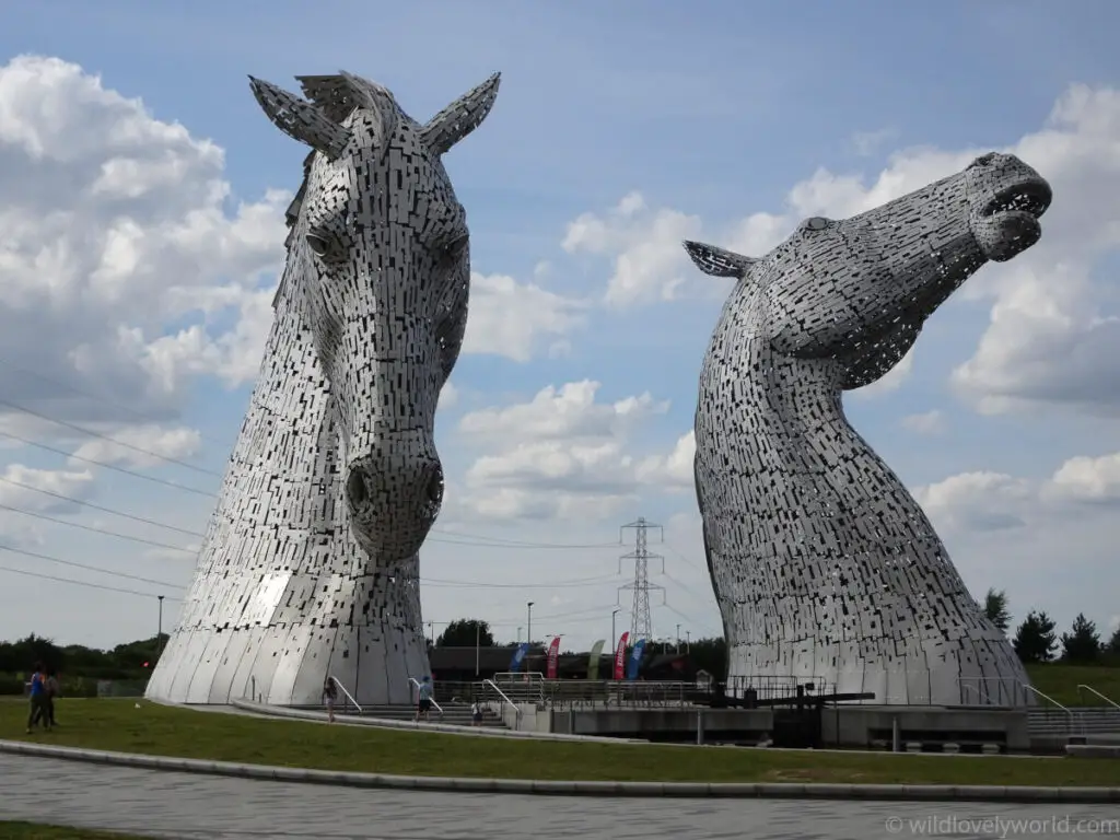 the kelpies falkirk sculpture viewing from the front with people walking below