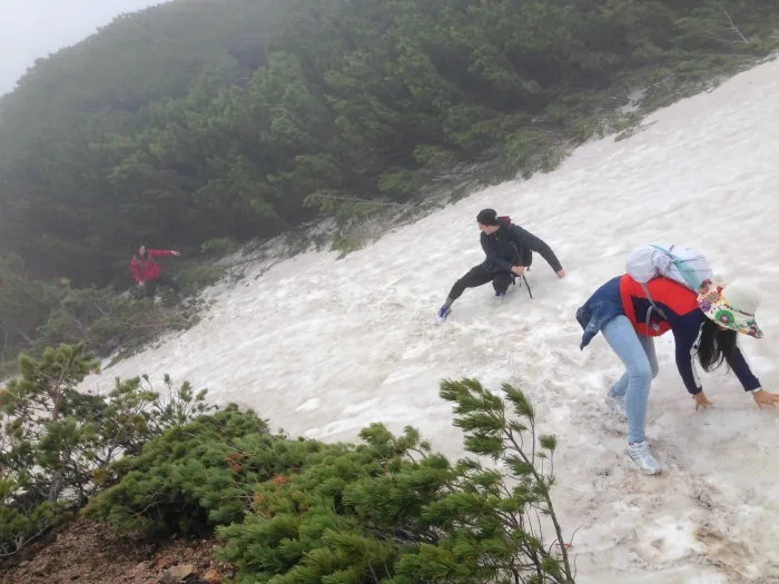 hikers crossing snow fields on mount meakan hokkaido japan