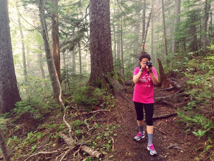 woman taking photographs in a forest