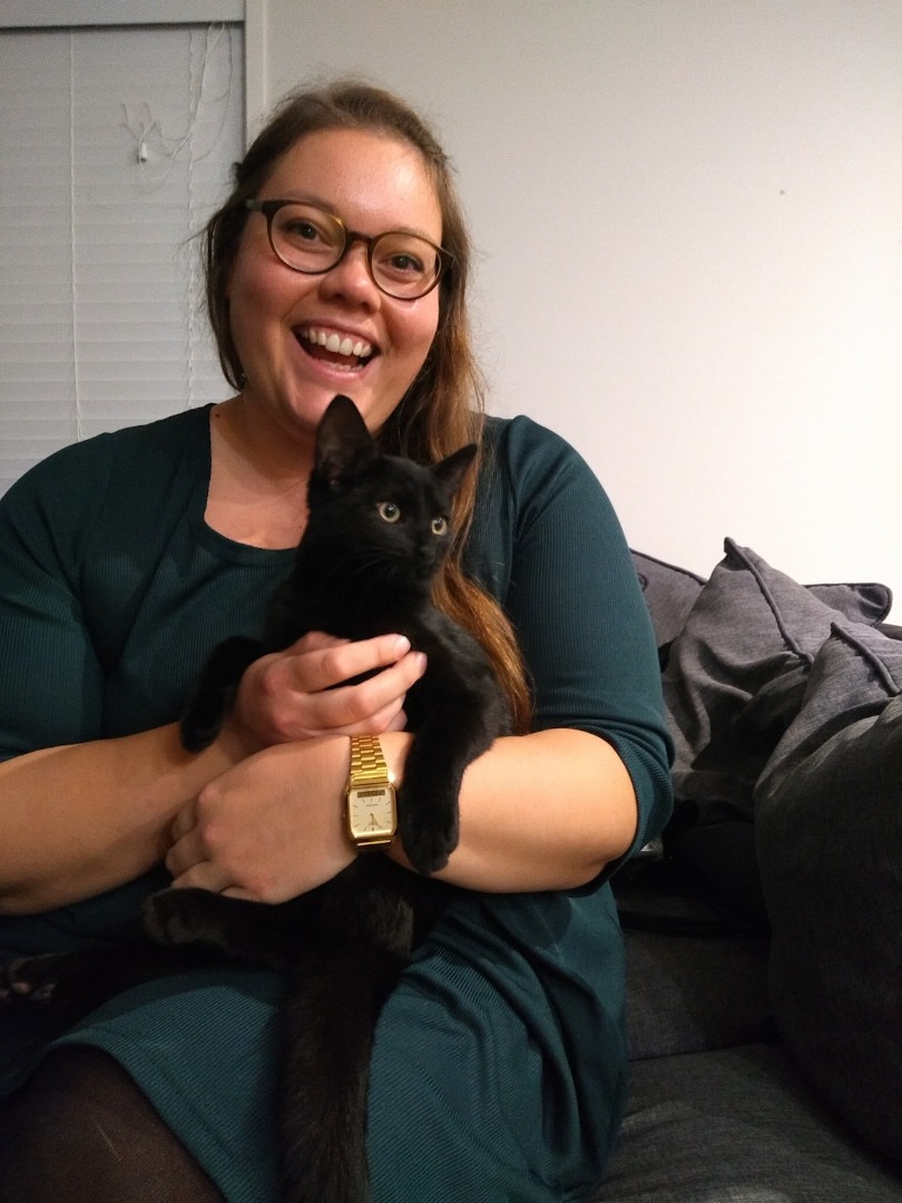 lauren smiling holding black cat sitting become a cat sitter