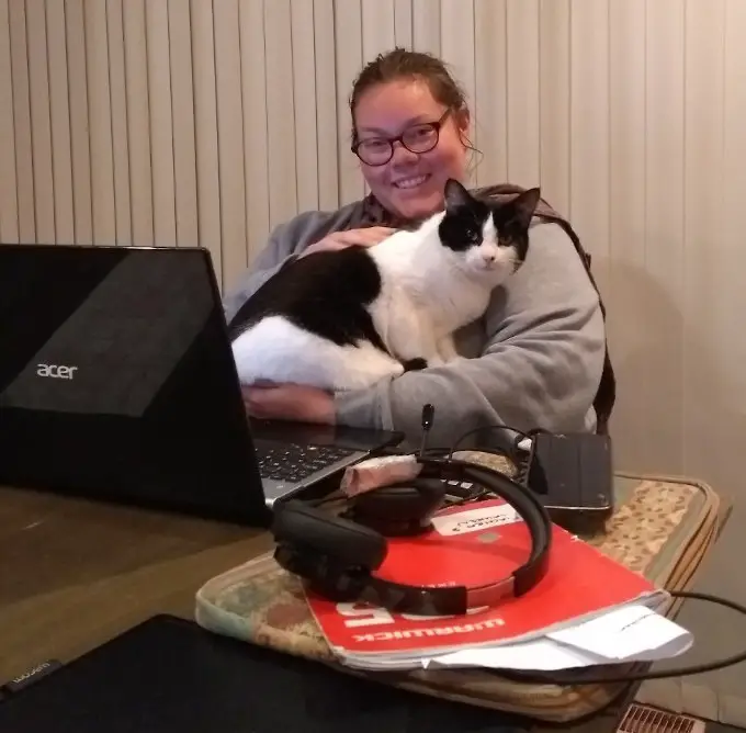 woman at computer with cat sitting on lap