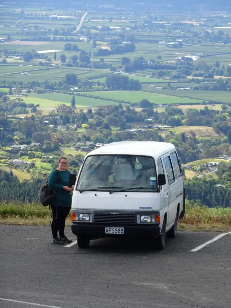 woman next to campervan on hill in hawkes bay new zealand