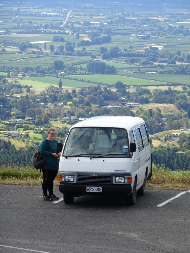 woman next to campervan on hill in hawkes bay new zealand