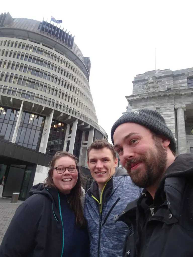 lauren fiachra and friend andy outside the new zealand parliament beehive building in wellington