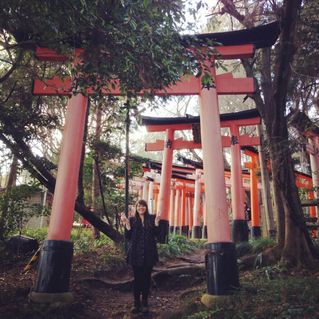 lauren standing in front of a tori gate in kyoto, japan