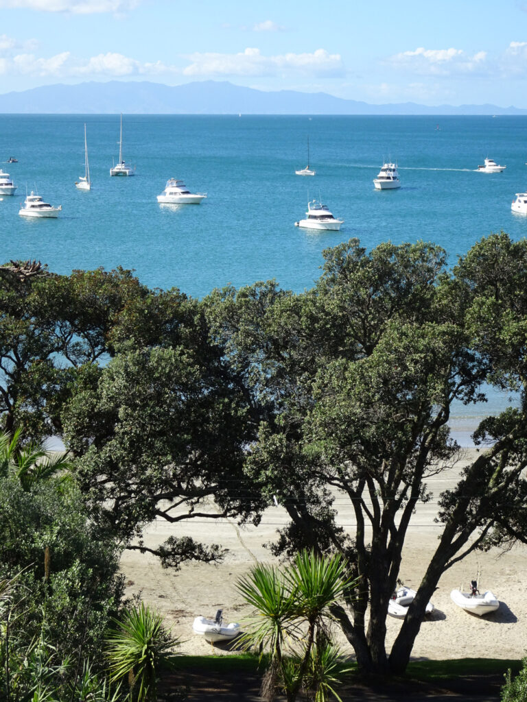 oneroa beach and bay with boats on the water waiheke island