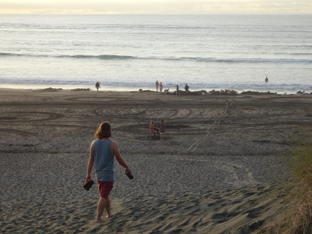 man walking on kawhia hot water beach north island new zealand