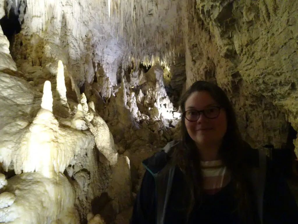 lauren inside aranui cave with beautiful cave formations in waitomo new zealand - a must do experience in the north island