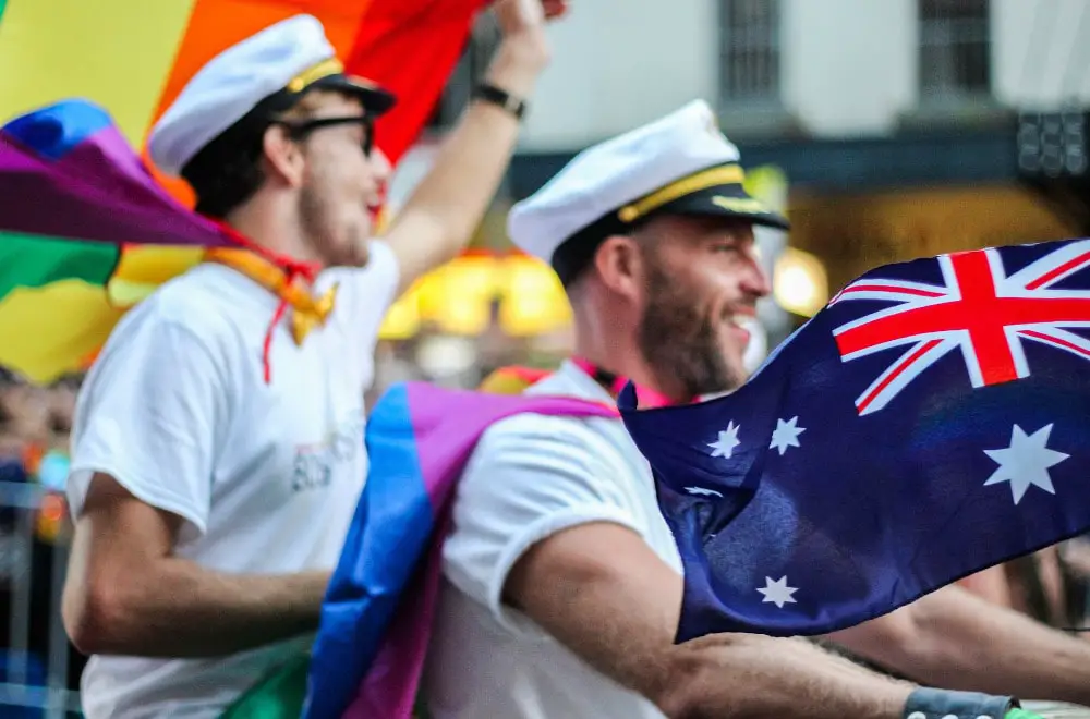 two men with lgbtq pride flags and australian flags in sydney australia
