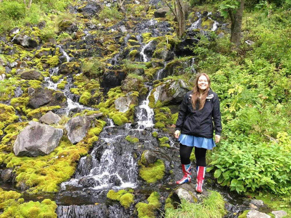 lauren standing at a moss covered waterfall in hokkaido japan