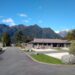 sunny day with blue sky and clearly visible green mountains at fox glacier top 10 holiday park new zealand