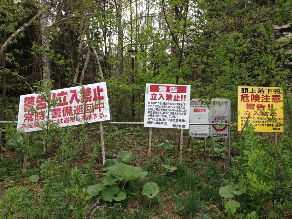 warning signs in japanese at the entrance to the abandoned german style theme park near obihiro in hokkaido japan - the gluck kingdom