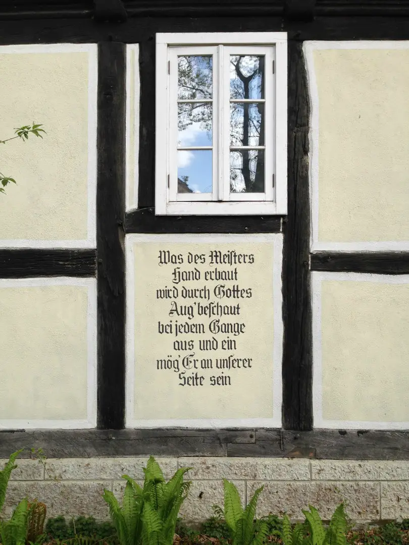 german writing on the wall outside a building underneath a window