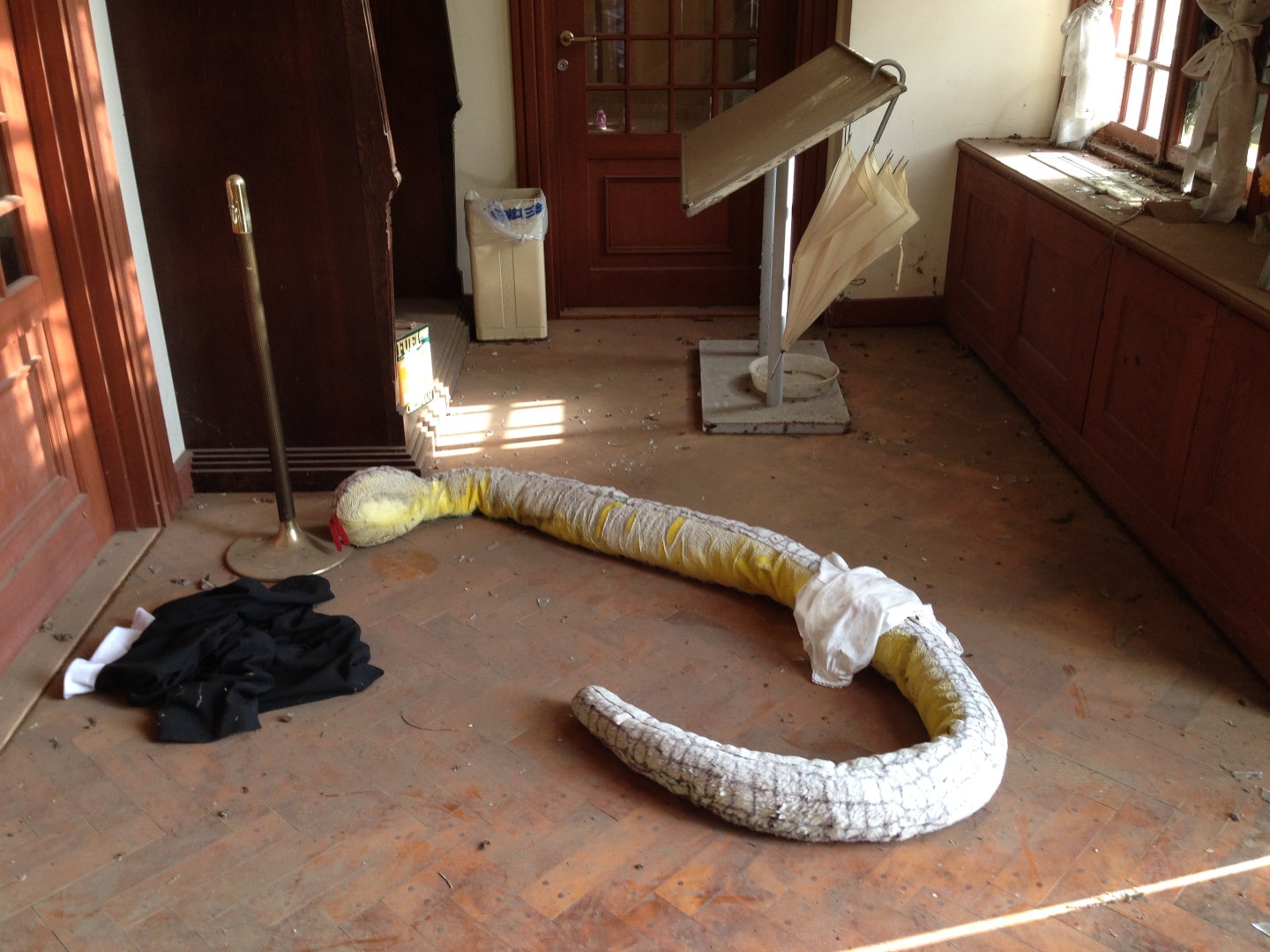 a giant yellow and white stuffed toy snake lying on the floor