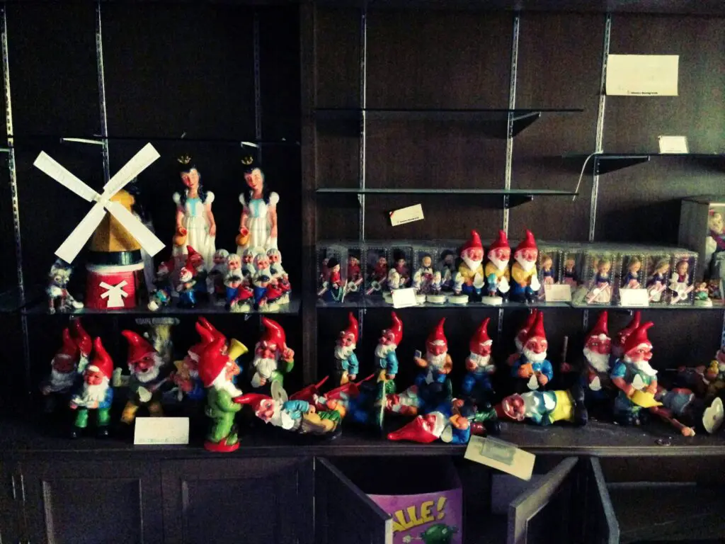 windmill, maid, and gnome figurines on a shelf in the gluck kingdom gift shop - abandoned german style theme park in hokkaido japan
