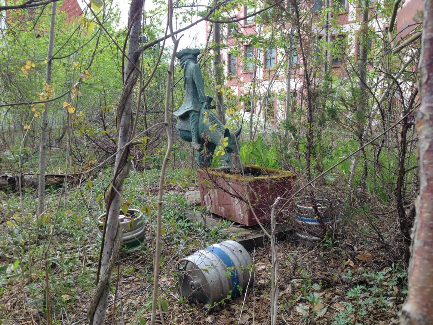 statues and barrels abandoned in the overgrown forest at the gluck kingdom - abandoned german theme park in hokkaido japan