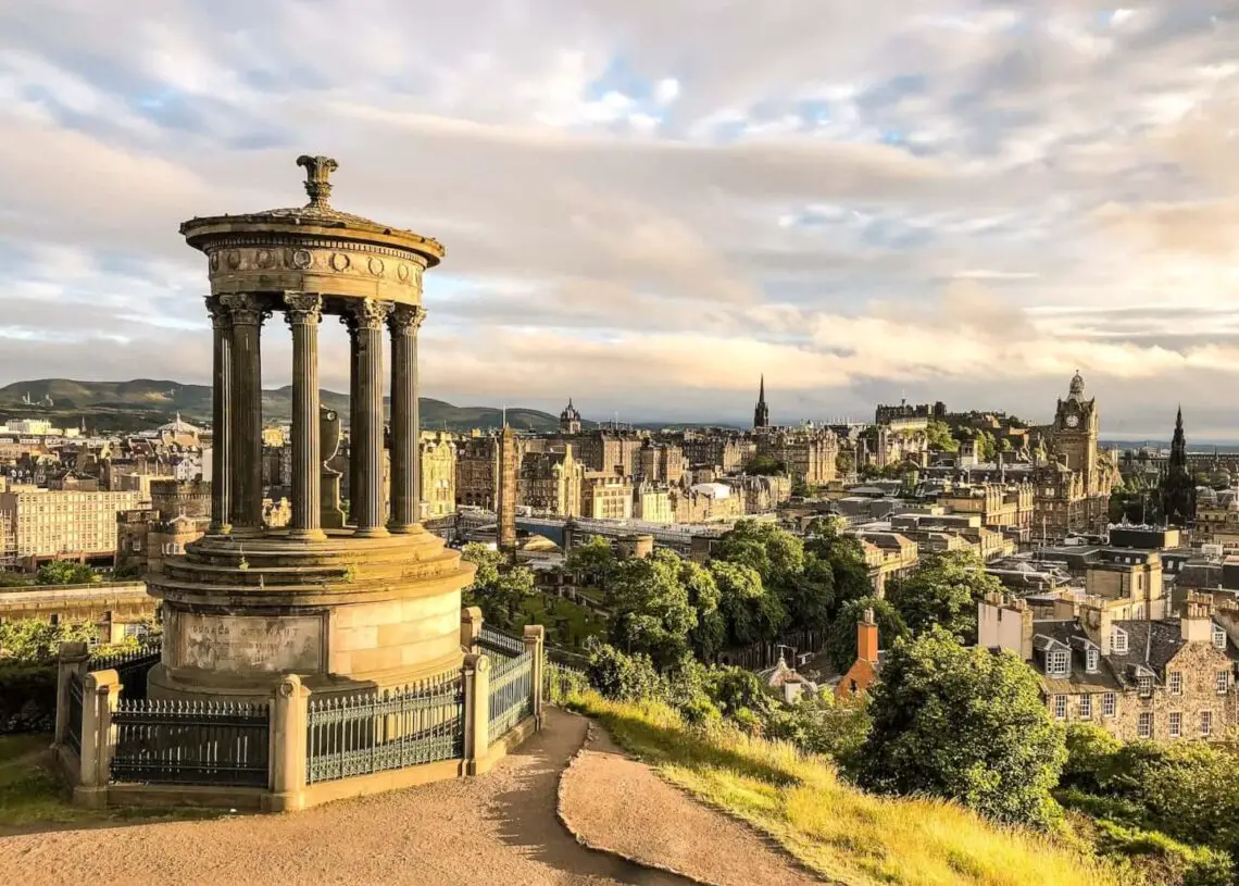calton hill edinburgh view with dugald stewart monument, balmoral hotel and edinburgh castle - everything you need to know about calton hill in edinburgh - wild lovely world travel blog