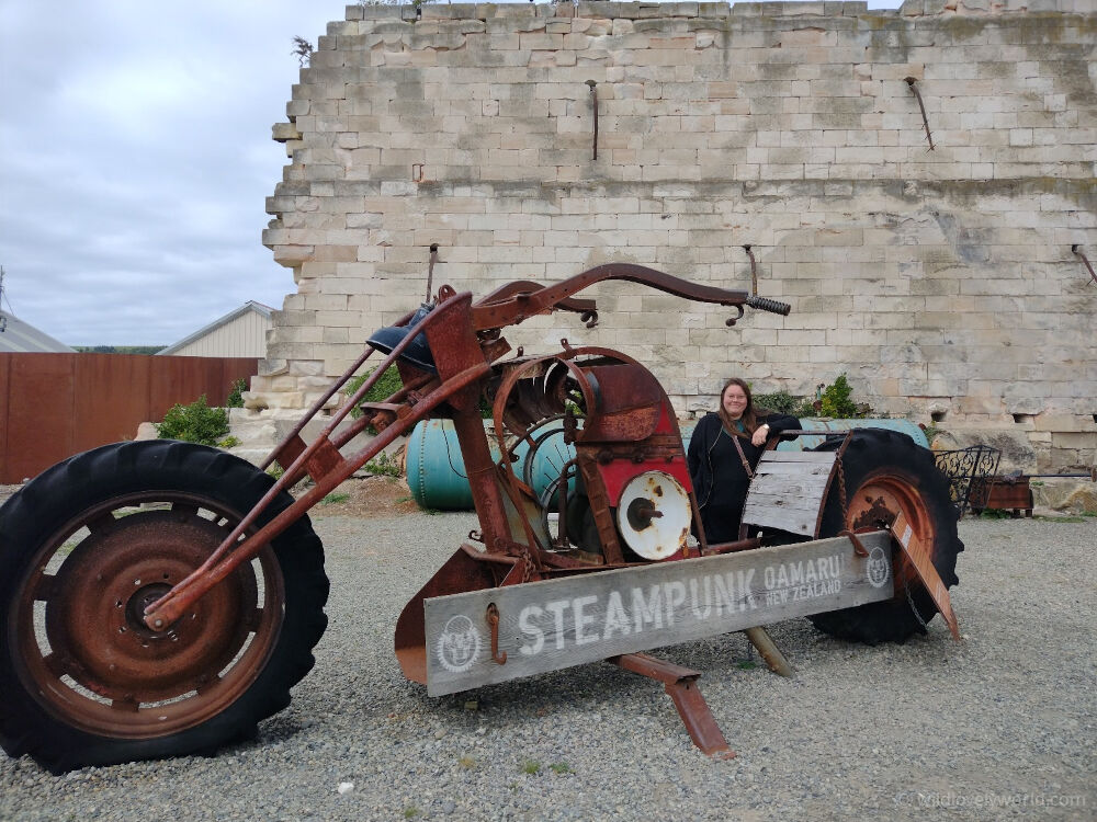 lauren standing with the giant motorbike at the steampunk hq museum in oamaru new zealand