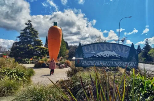 lauren standing in front of ohakune's big carrot statue at the ohakune carrot adventure park - giant sculpture in new zealand