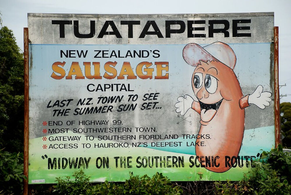 tuatapere new zealand's sausge capital - last n.z. town to see the summer sun set... - roadside sign at the entrance to tuatapere