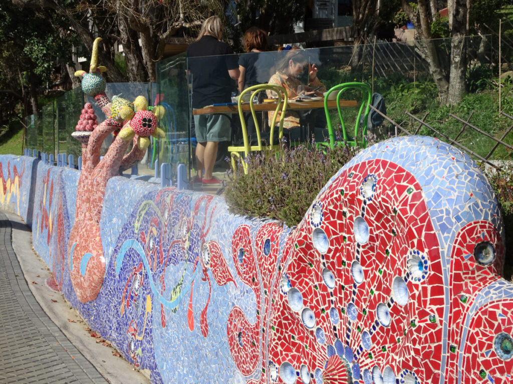 a colorful and decorative ceramic mosaic wall at casita miro winery on waiheke island, mainly blue and red in colour with patterns and swirls