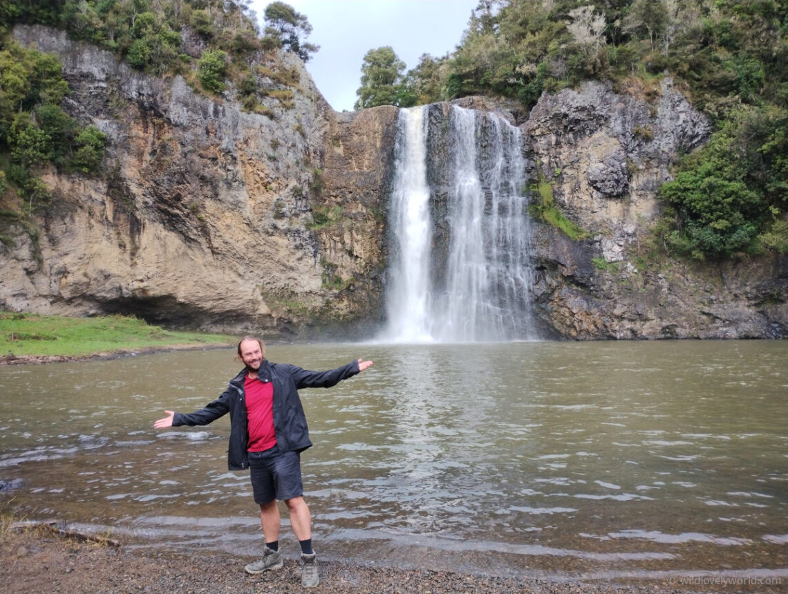 fiachra smiling with arms outstretched at hunua waterfalls, auckland, north island, new zealand