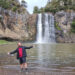 fiachra smiling with arms outstretched at hunua waterfalls, auckland, north island, new zealand