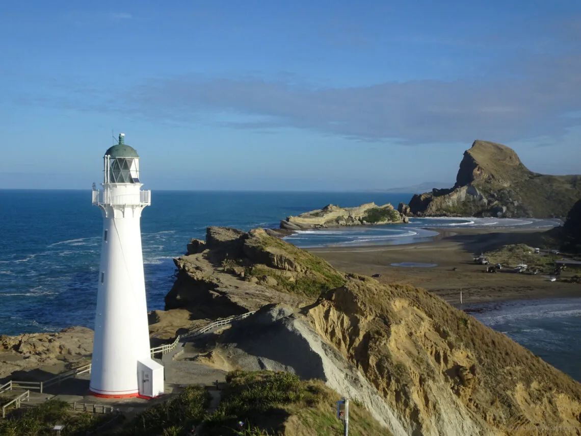view of castle point lighthouse, beach, and castle rock, at the castlepoint scenic reserve, in wairarapa, north island, new zealand