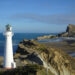 view of castle point lighthouse, beach, and castle rock, at the castlepoint scenic reserve, in wairarapa, north island, new zealand