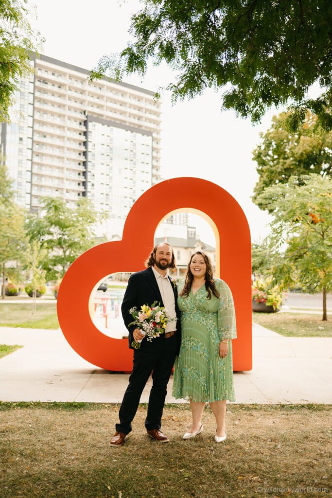 lauren and fiachra on their wedding day in waterloo ontario canada with the heart symbol in the park