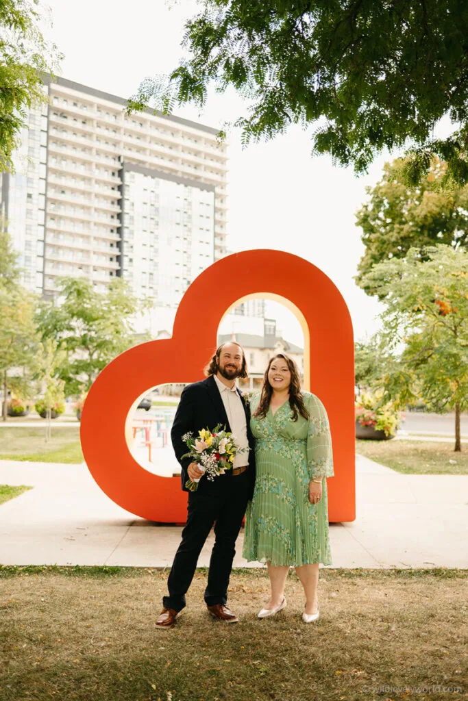 lauren and fiachra on their wedding day in waterloo ontario canada with the heart symbol in the park