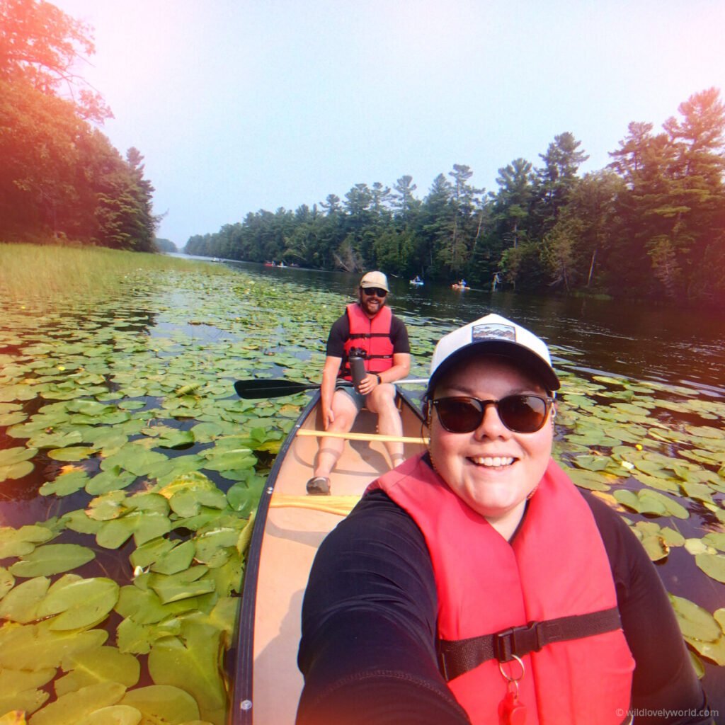 lauren takes a selfie of her and fiachra in a canoe surrounded by lily pads at pinery provincial park in ontario