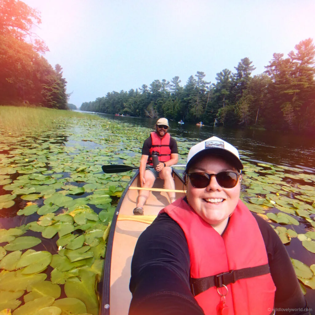 lauren takes a selfie of her and fiachra in a canoe surrounded by lily pads at pinery provincial park in ontario