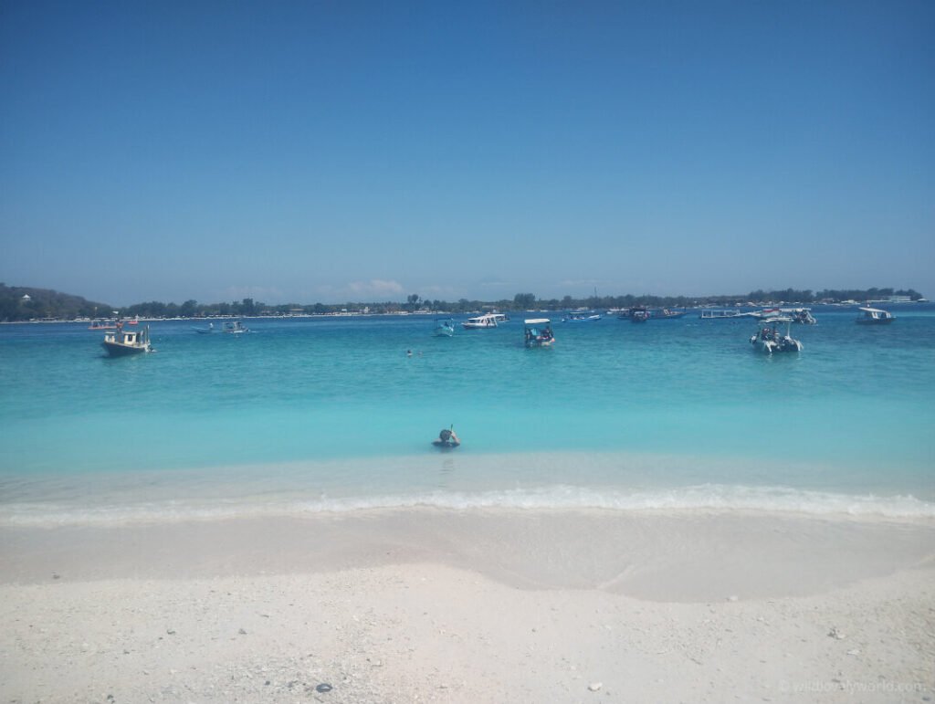 fiachra at the beach entering the water to snorkel at the best snorkelling spot in front of mahamaya resort on gili meno island indonesia