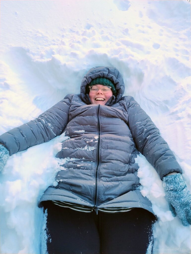 lauren lying in snow and smiling