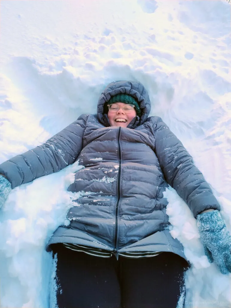 lauren lying in snow and smiling